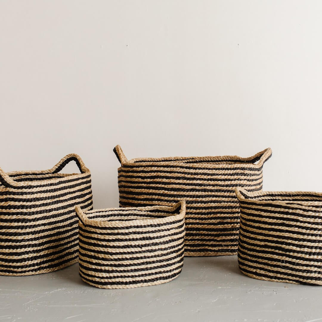 Handwoven Oval Jute Basket in stripes, perfect for home organization and storage. Available in four sizes: mini, small, medium and large.