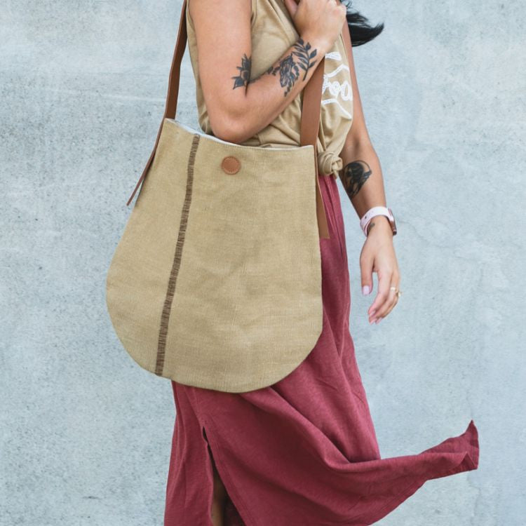 The Archer Jute Tote Bag in natural, a gorgeous accessory, with a jute canvas exterior and interior cotton lining, along with a strong, leather handle it's perfect for everyday use or trips to the farmer's market.