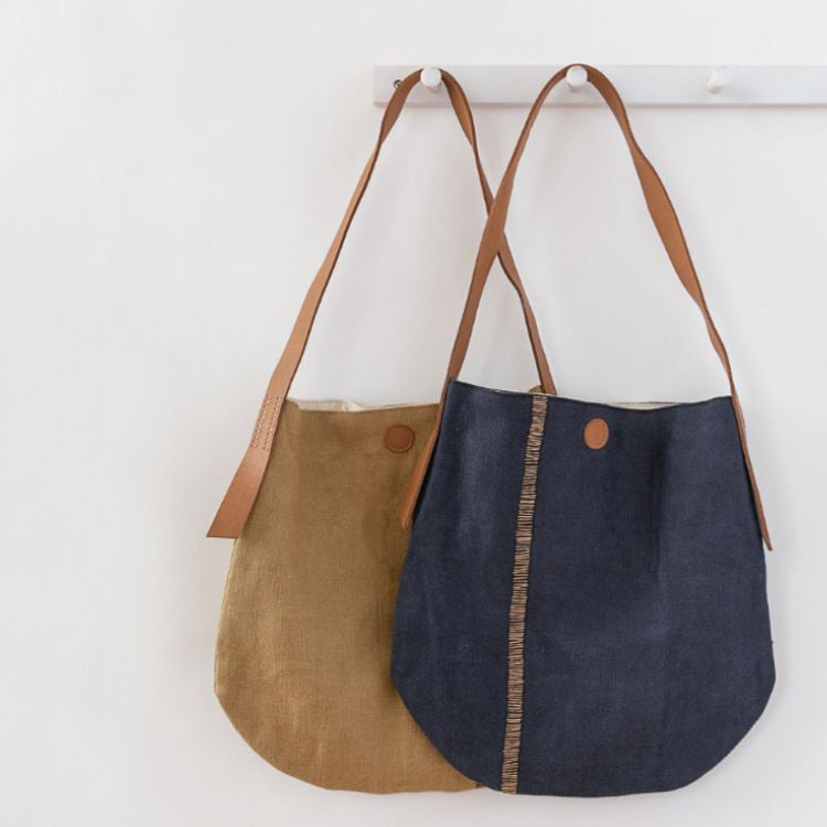 The Archer Jute Tote Bag in natural and indigo, a gorgeous accessory, with a jute canvas exterior and interior cotton lining, along with a strong, leather handle it's perfect for everyday use or trips to the farmer's market.