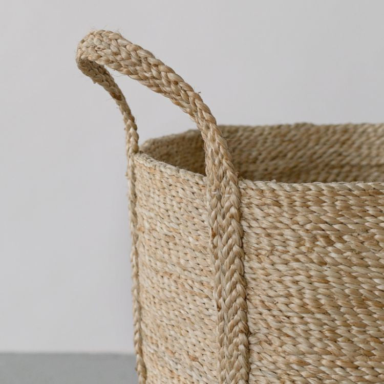 Handcrafted round jute laundry basket in natural, perfect for storing and transporting laundry, blankets, towels and other household items.