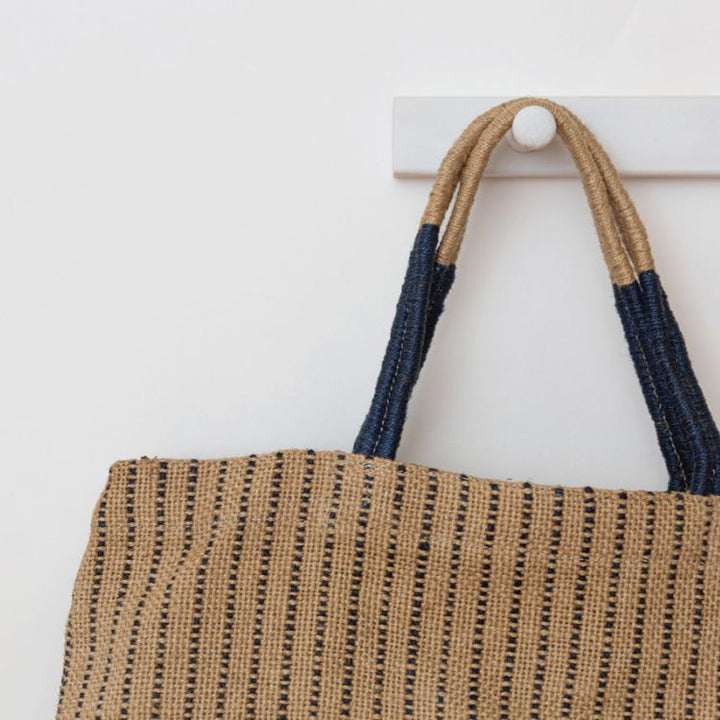 Our indigo stripe Jute Shopper is handcrafted with eco-friendly jute plant fibers and natural dyes. Our jute shopper is ready to accompany you on many an errand, from the grocery store to your favorite boutique. 