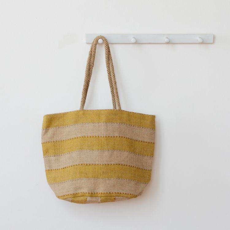Our Khari Market Tote is handcrafted from jute, with grey, spice, or gold detailing. Whether your style is elegant minimalism or all things warm and bright, your Khari Market Tote is ready for each day’s adventures.