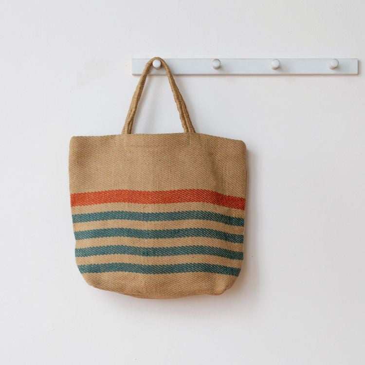 Jute tote bag in blue and beige stripes with reinforced handles, ideal for groceries, beach items, and everyday essentials. Eco-friendly and sustainable alternative to plastic bags, by Will & Atlas.