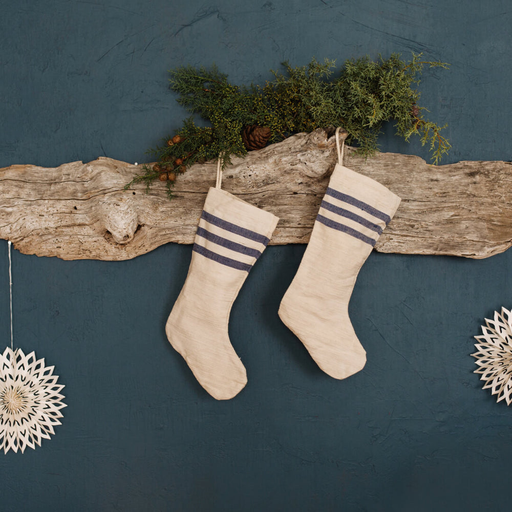 Handcrafted holiday stocking with natural cotton, neutral tones and striped detailing, perfect for rustic decor and hanging on your mantel or staircase.