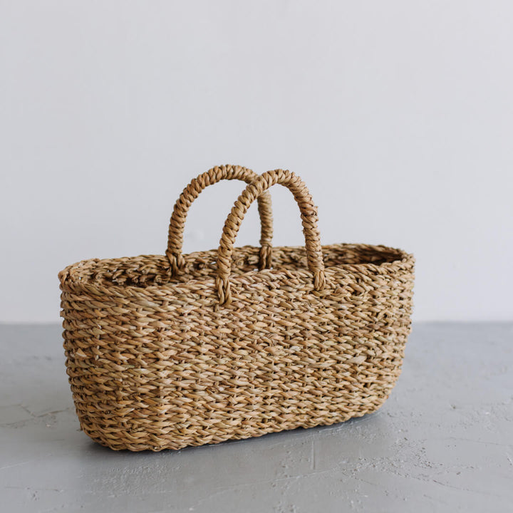 The Harvest gathering basket is handcrafted from hogla grass, an aquatic plant. Woven together, it creates a design that's both lightweight and strong, with layers of natural texture and tone.