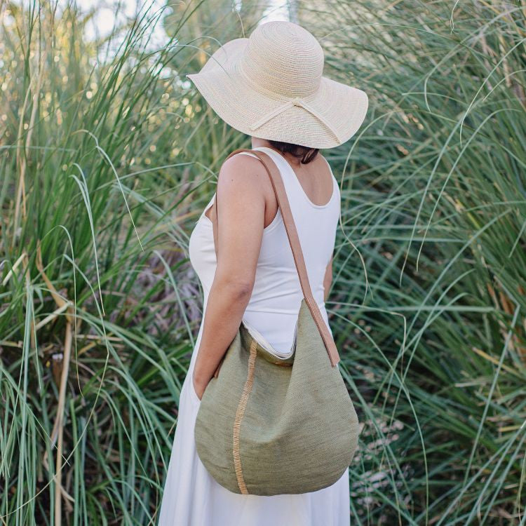 The Archer Jute Tote Bag in olive, a gorgeous accessory, with a jute canvas exterior and interior cotton lining, along with a strong, leather handle it's perfect for everyday use or trips to the farmer's market.