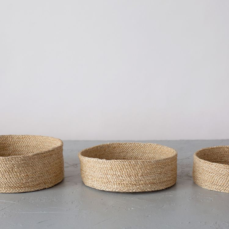 A trio of handwoven natural jute baskets, perfect for storing household items and adding natural texture to your decor.