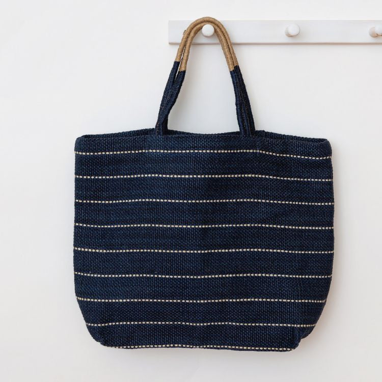 Handcrafted Marin jute shopper bag in indigo with striped detailing and a woven, colorblocked handle, made using natural dyes and eco-friendly jute fibers from Bangladesh.