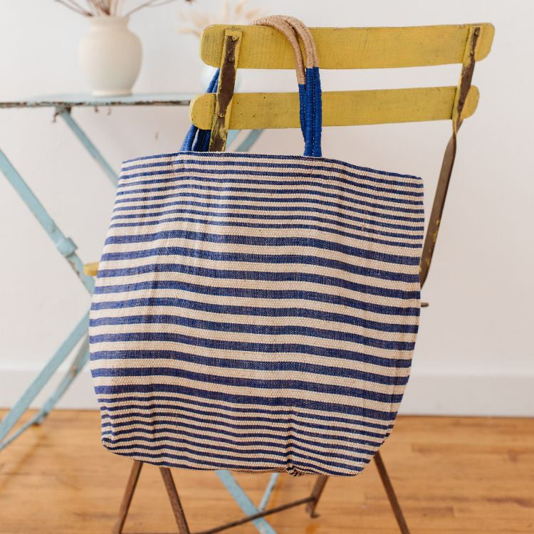 Paloma striped shopper with durable suede handles and zipper closure. In indigo striped detailing and natural jute fiber. Stylish and versatile accessory from Will & Atlas.