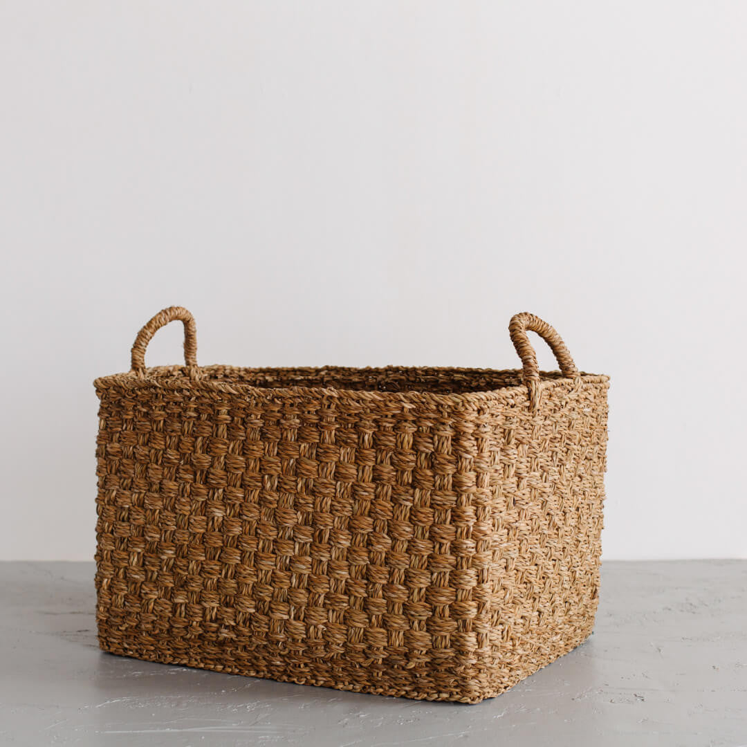 The Harvest rectangle basket is handcrafted from hogla grass, an aquatic plant. Woven together, it creates a design that's both lightweight and strong, with layers of natural texture and tone.