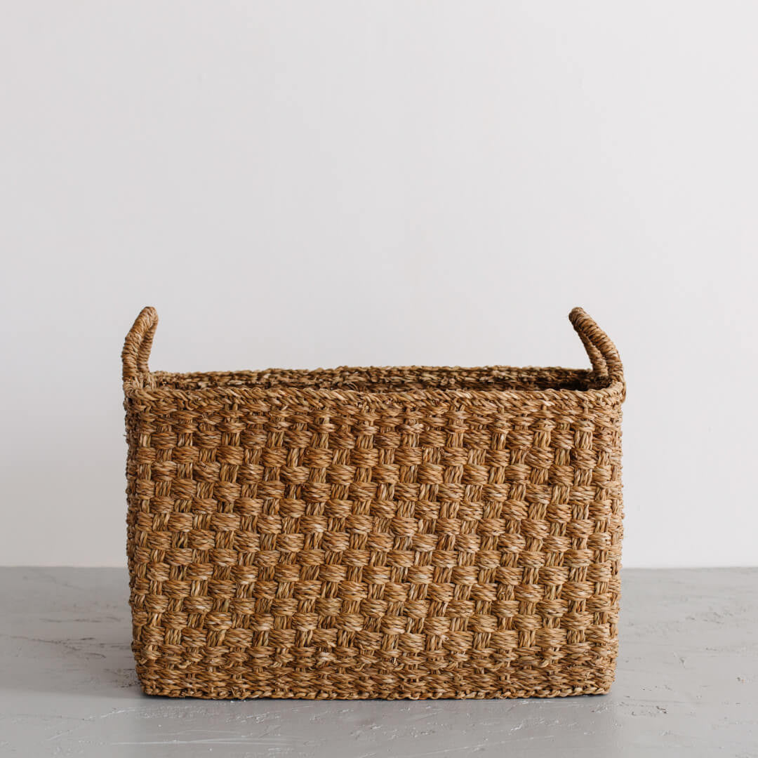 The Harvest rectangle basket is handcrafted from hogla grass, an aquatic plant. Woven together, it creates a design that's both lightweight and strong, with layers of natural texture and tone.