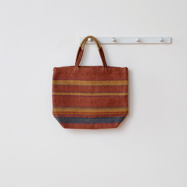 Eco-friendly jute tote bag with reinforced handles, perfect for groceries, beach items, and everyday essentials. The Sedona Market Jute Shopper features a stylish beige and black striped design, by Will & Atlas.