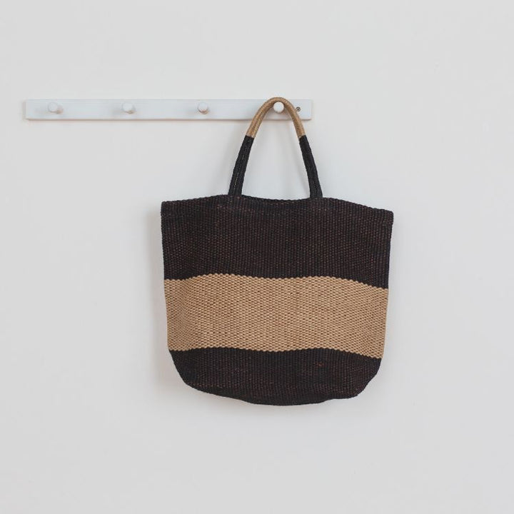 Eco-friendly jute tote bag with reinforced handles, perfect for groceries, beach items, and everyday essentials. The Soho Market Jute Shopper features a chic black and natural color block design, by Will & Atlas.