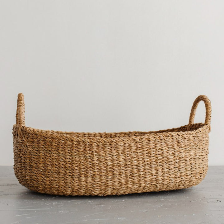 We love the way the light dances on our Harvest baskets! From rich chestnut to golden brown, the hues and tones are simply gorgeous. Our Harvest baskets are handwoven with hogla grass, an aquatic plant. Like jute, hogla grass is knows for its durability and natural beauty. Each basket features double handles for easy carrying. (large oval basket)
