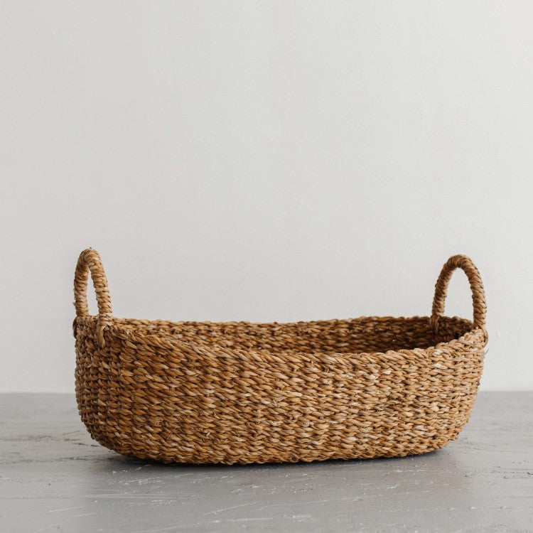 We love the way the light dances on our Harvest baskets! From rich chestnut to golden brown, the hues and tones are simply gorgeous. Our Harvest baskets are handwoven with hogla grass, an aquatic plant. Like jute, hogla grass is knows for its durability and natural beauty. Each basket features double handles for easy carrying. (medium oval basket)
