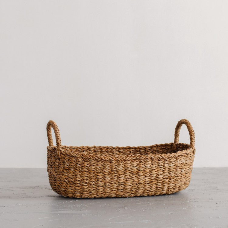 We love the way the light dances on our Harvest baskets! From rich chestnut to golden brown, the hues and tones are simply gorgeous. Our Harvest baskets are handwoven with hogla grass, an aquatic plant. Like jute, hogla grass is knows for its durability and natural beauty. Each basket features double handles for easy carrying. (small oval basket)
